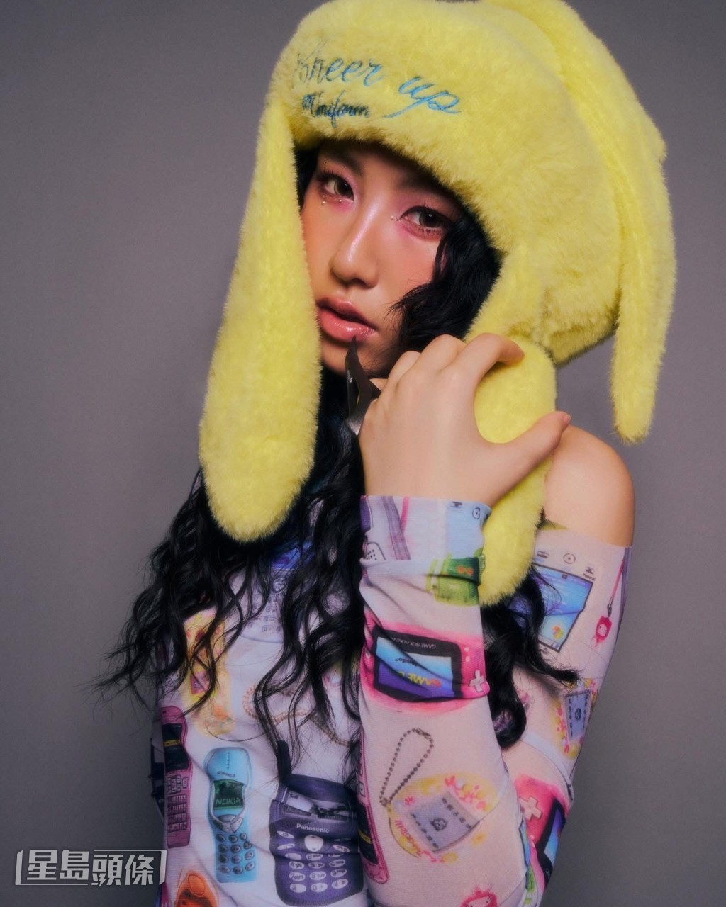 见她留有一头长卷发，画上浓妆。