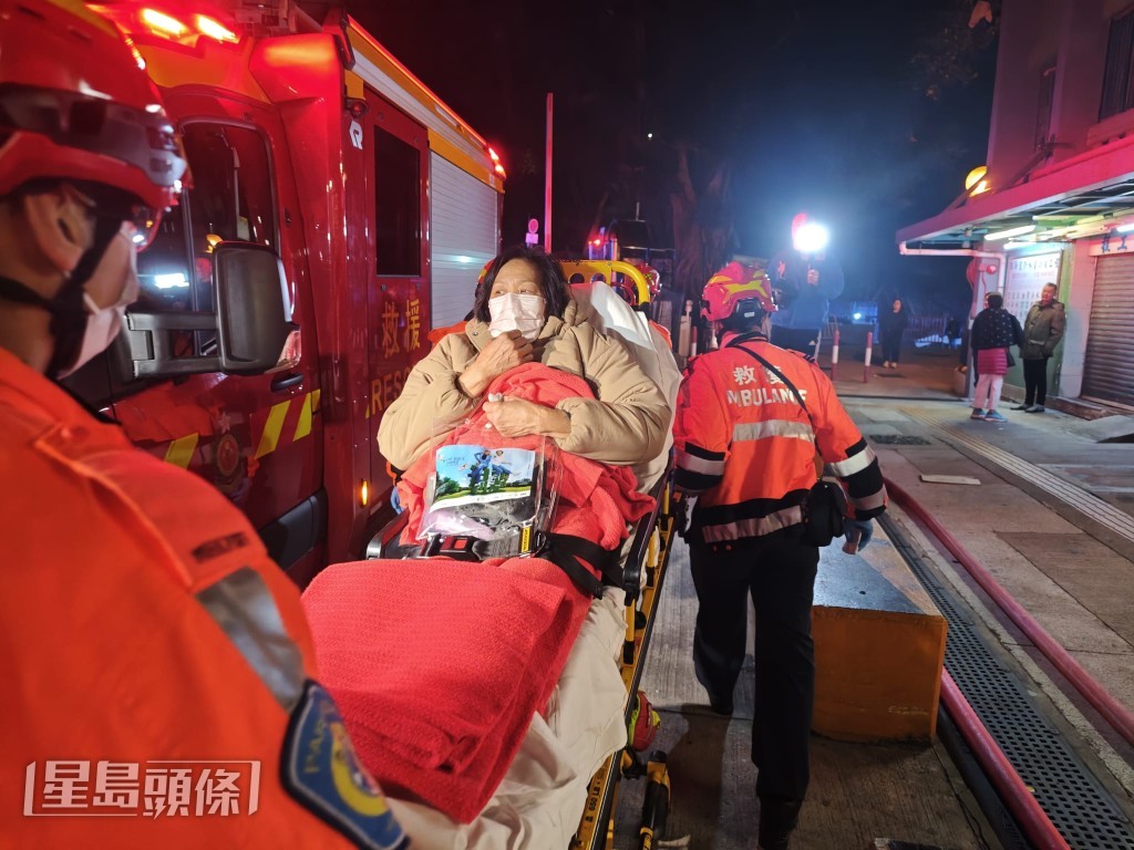 起火单位69岁女户主事后戴上口罩，一脸余悸在担架床上。蔡楚辉摄