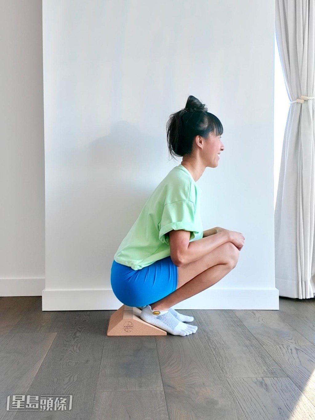 步驟2：如果平衡有困難，可以背靠著牆、手扶着門框、或者腳踝下墊一墊輔助物，讓腳跟稍稍抬起。（由伸展治療導師Czon Wong提供）