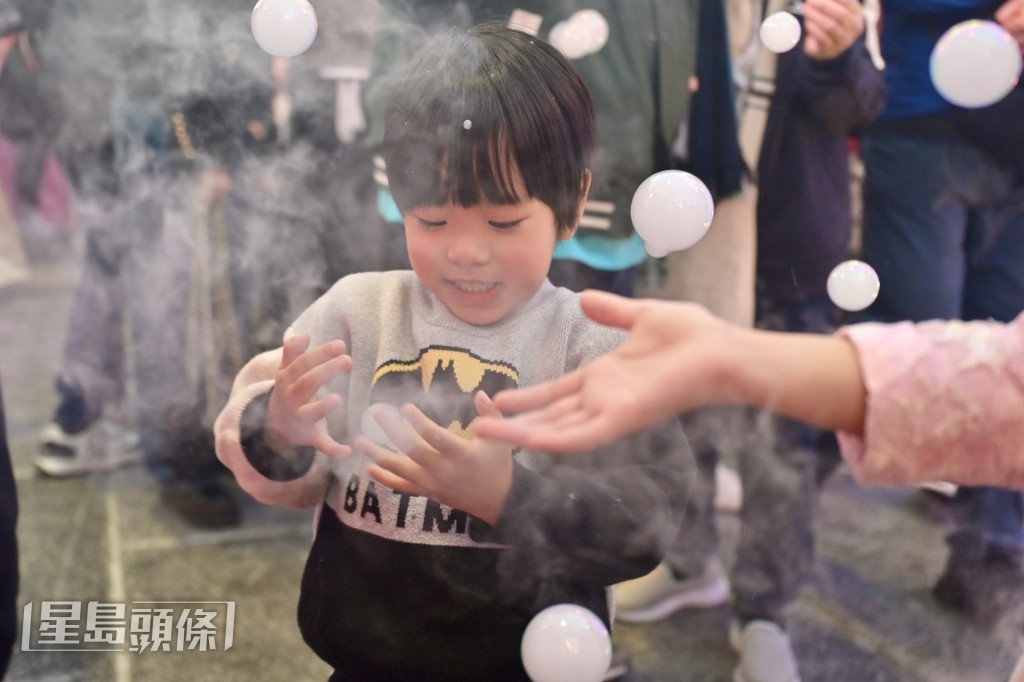 烟雾泡泡营造漫天飘雪效果，小孩笑逐颜开。