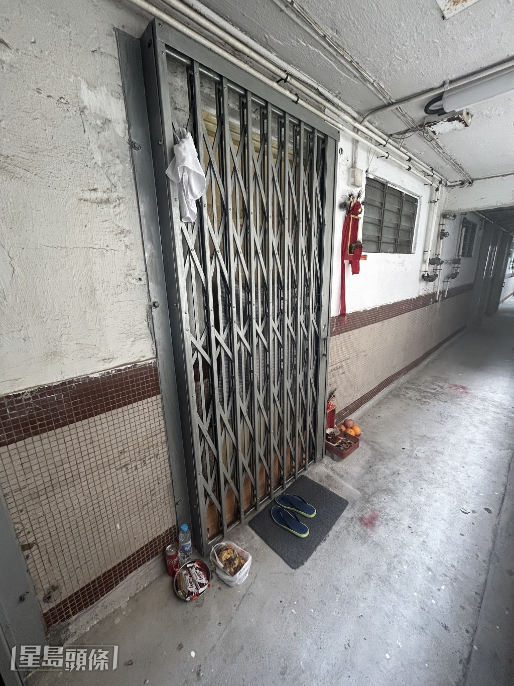 死者門口鐵閘掛上一條白毛巾。楊偉亨攝 死者門口鐵閘掛上一條白毛巾。楊偉亨攝