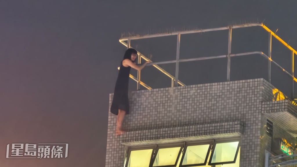 女子危站在狹窄簷篷上,期間她不時查看手機,險象環生。黎志偉攝 女子危站在狹窄簷篷上,期間她不時查看手機,險象環生。黎志偉攝
