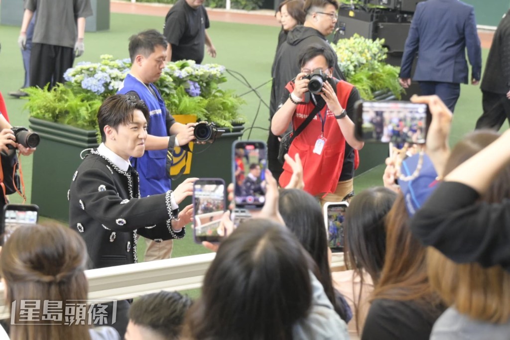 他完成演出後又走到粉絲面前揮手打招呼,場面熱鬧。 他完成演出後又走到粉絲面前揮手打招呼,場面熱鬧。