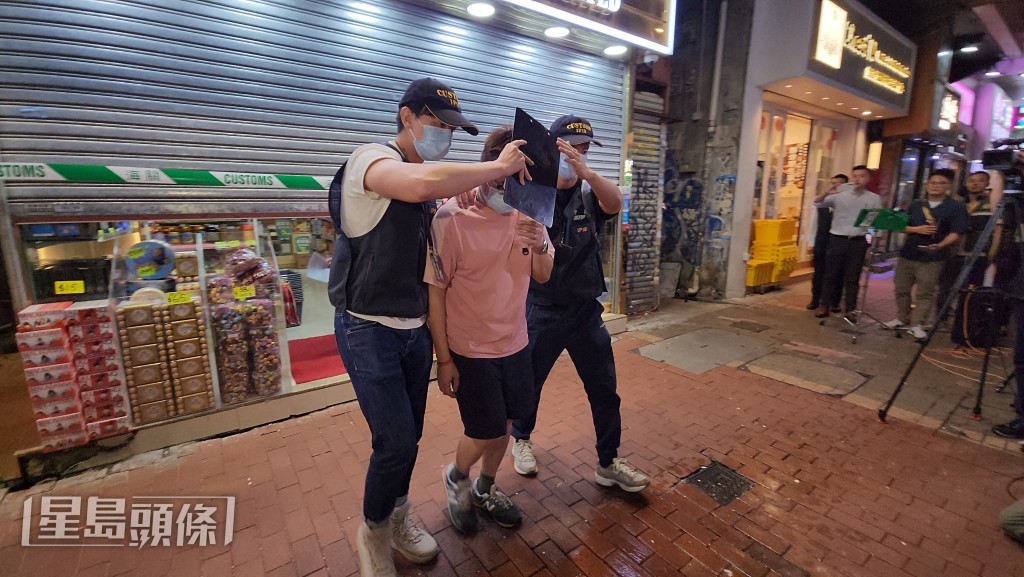 海關人員帶走涉案男店員。黃文威攝