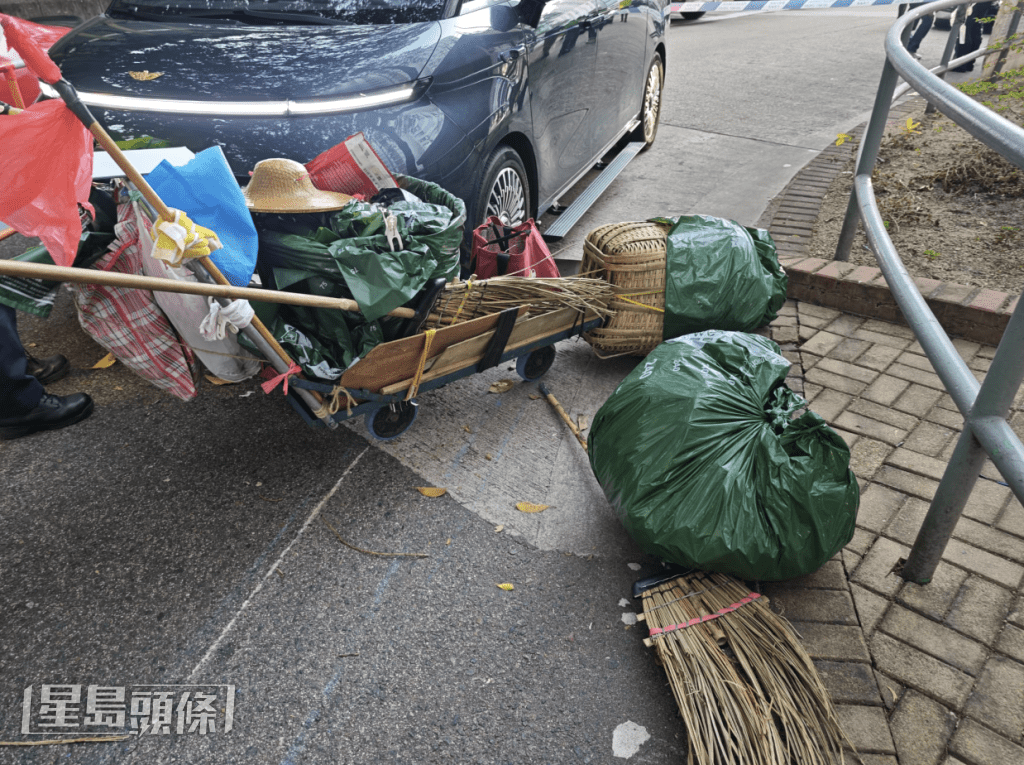 地上遺下一架手推車、大量清潔工具及數袋散落的垃圾。