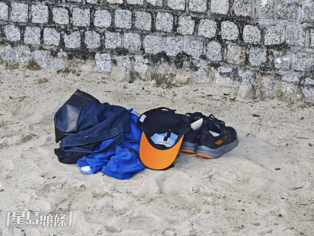 沙灘上有一堆疑是男事主遺下的物件，包括太陽帽、沙灘手挽袋及毛巾和衣物等。黎志偉攝