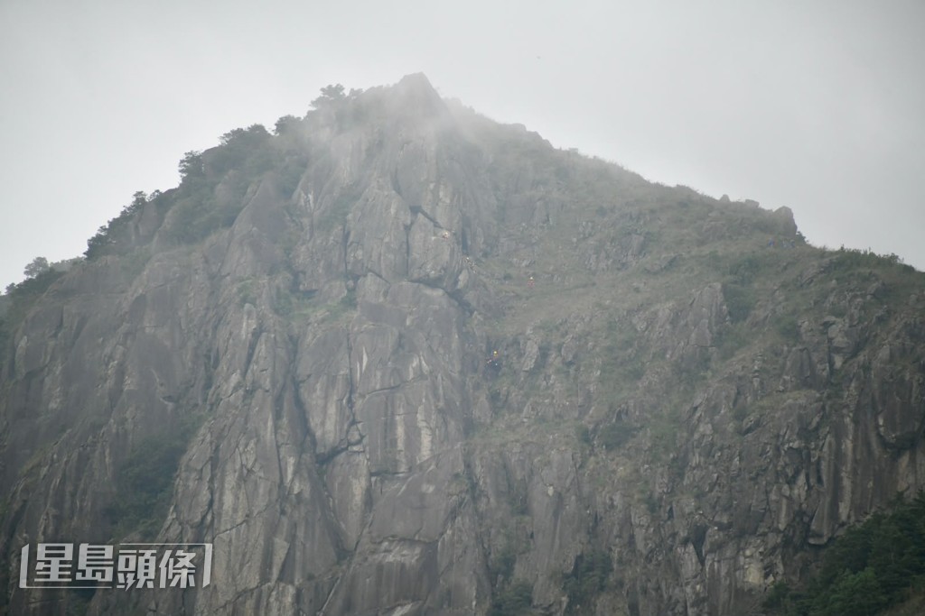 消防员在崖边游绳救援。杨伟亨摄 消防员在崖边游绳救援。杨伟亨摄