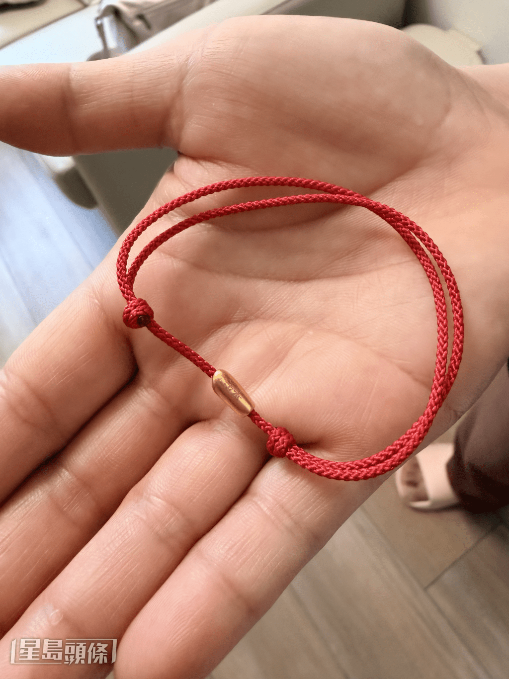 Jennifer展示開戶迎新禮物：一條「金米仔」手繩。