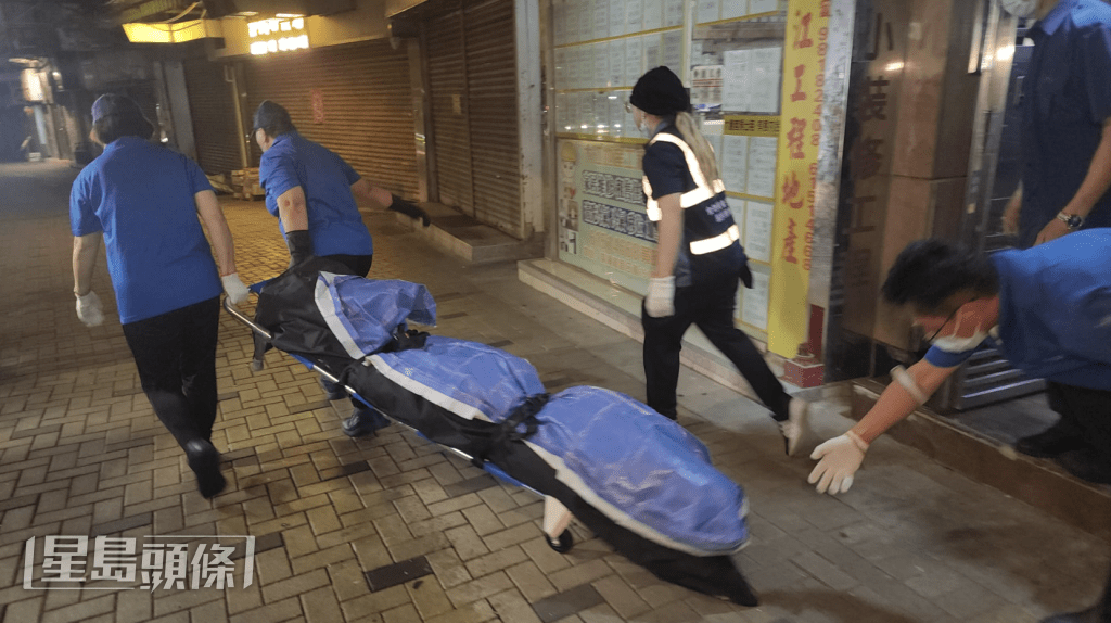 仵工從單位內舁走兩具遺體。