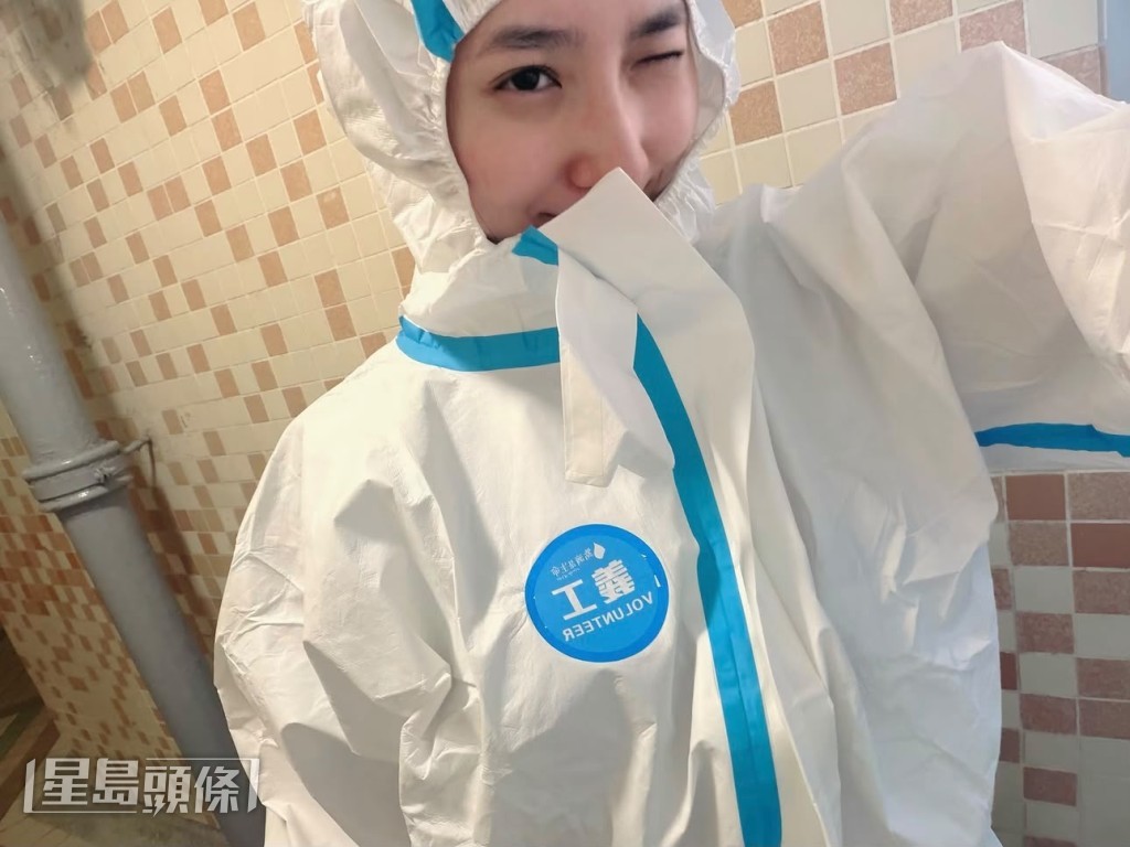 她穿上全套白色防護衣,佩戴口罩及手套。 她穿上全套白色防護衣,佩戴口罩及手套。