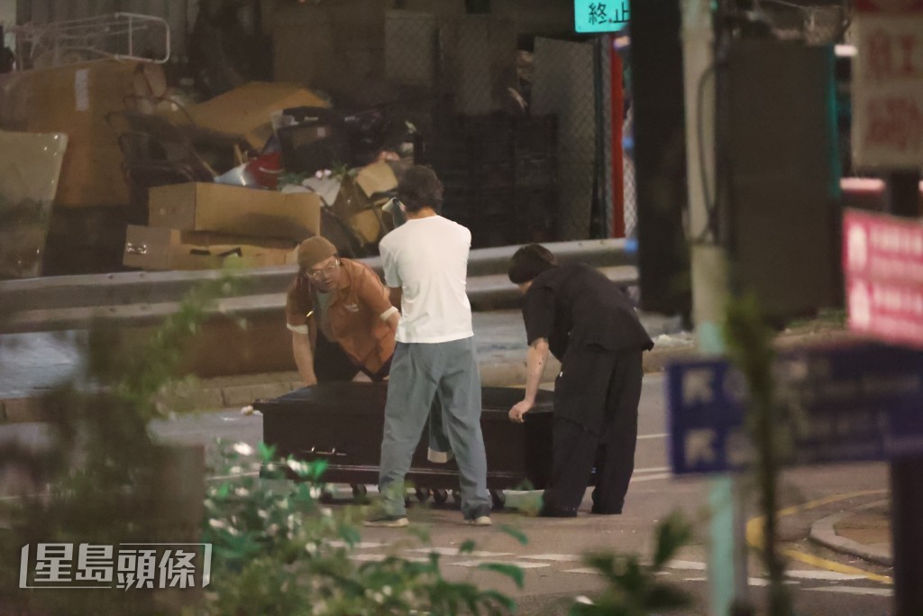 三人街頭推棺材，畫面充滿黑色幽默。
