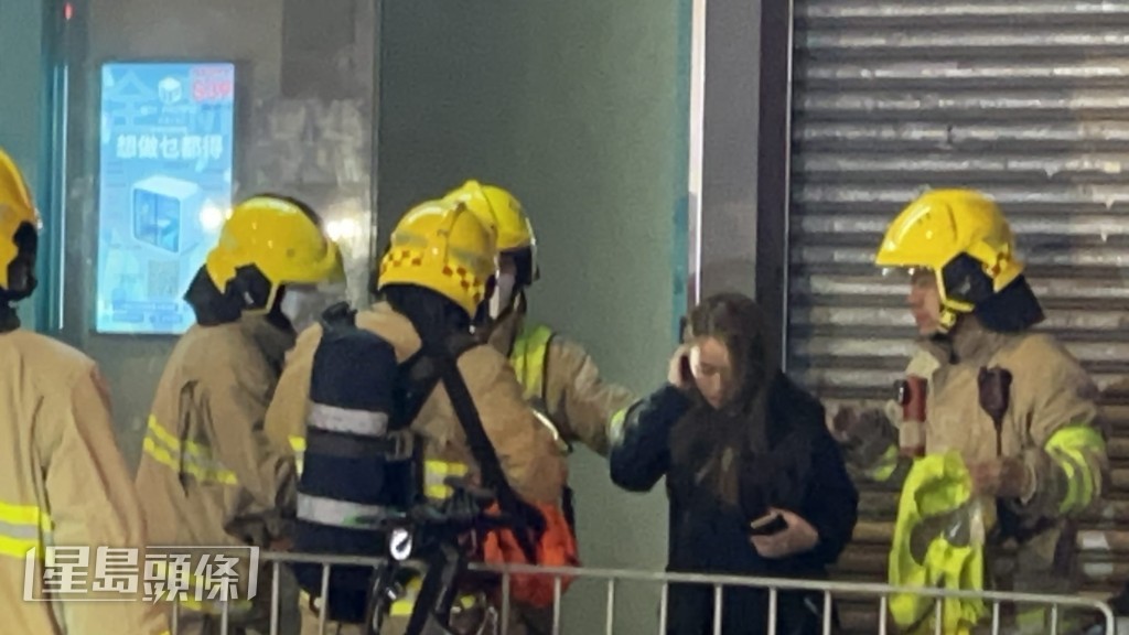 一名疑似派對房間女負責人到場，消防為她帶上防煙面罩，陪同她一同到地庫了解情況。蔡楚輝攝