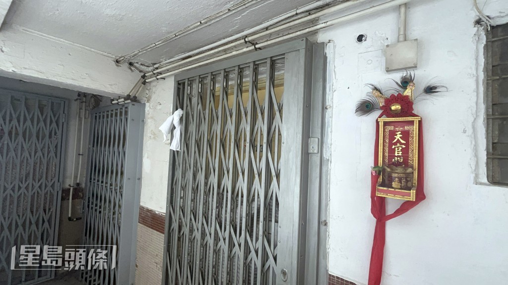死者門口鐵閘掛上一條白毛巾。楊偉亨攝 死者門口鐵閘掛上一條白毛巾。楊偉亨攝