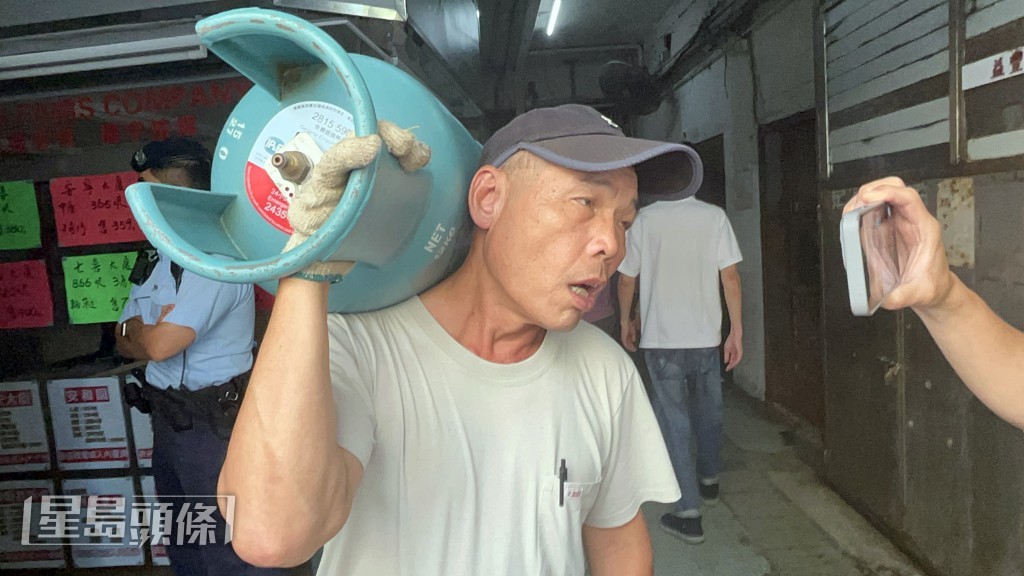 洪先生扛着石油氣罐從9樓下來。楊偉亨攝