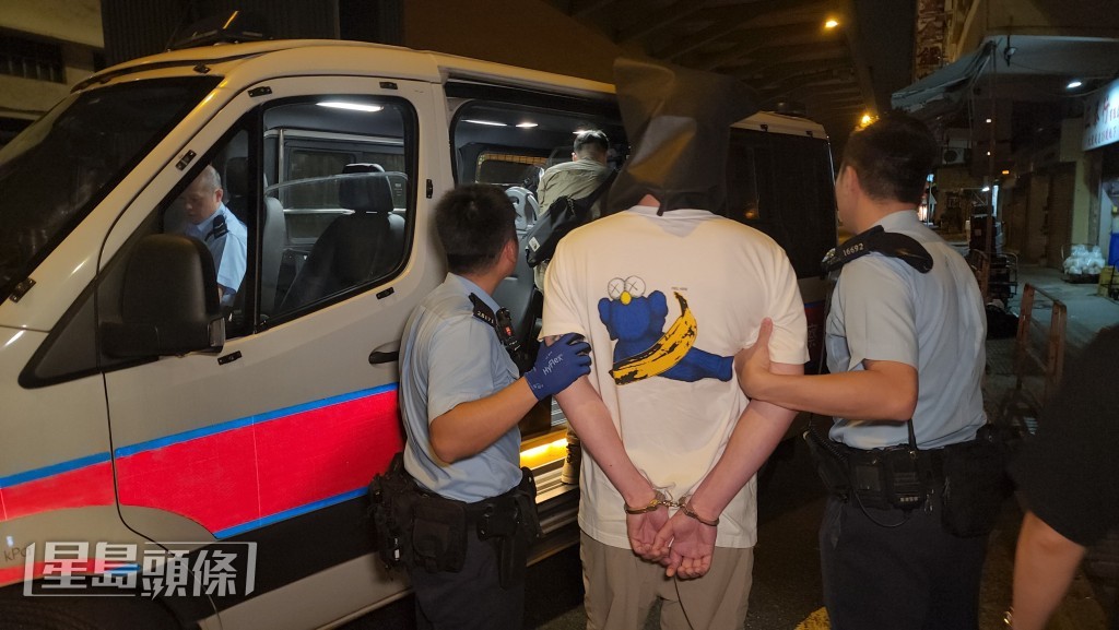 男子被戴上頭套帶返警署接受調查。