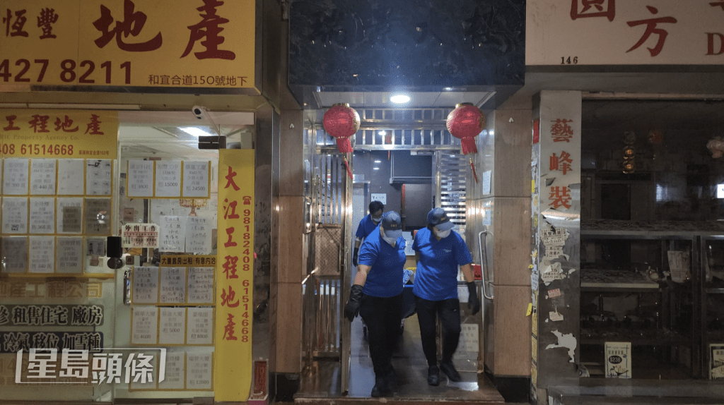 直至周日（17日）凌晨3時許，仵工從單位內舁走兩具遺體。黎志偉攝
