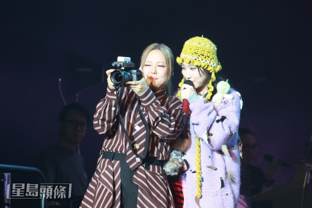 Janice拎起相機拍攝換上可愛造型的Gigi以及樂隊拍檔。
