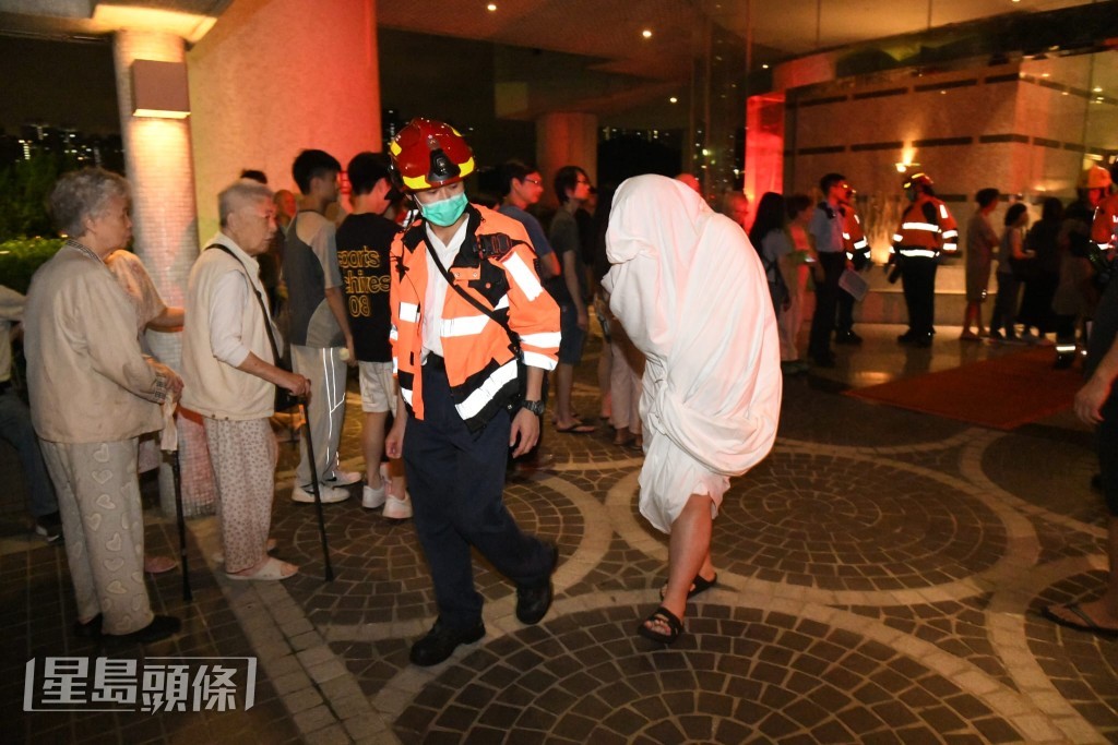 火警單位三名住戶不適送院,其中一人以白毛巾掩蓋全身。黎志偉攝 火警單位三名住戶不適送院,其中一人以白毛巾掩蓋全身。黎志偉攝