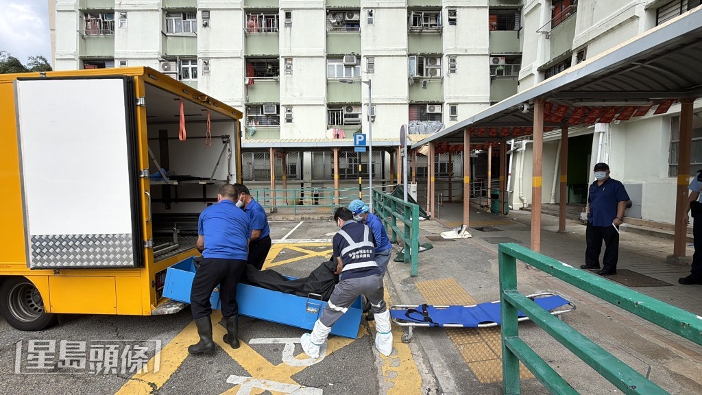 仵工移走男死者遺體。 仵工移走男死者遺體。
