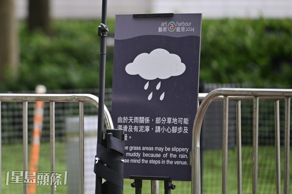 主辦方在現場豎起告示，提醒市民因天雨關係，草地可能濕滑。