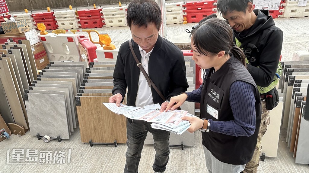 入境處人員在邨內向住戶派發宣傳單張。蔡楚輝攝