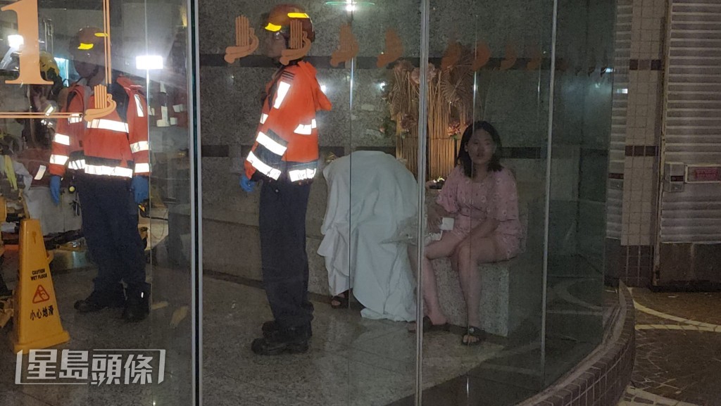 火警單位兩名住戶坐在大堂內,其中一人以白毛巾掩蓋全身。黎志偉攝 火警單位兩名住戶坐在大堂內,其中一人以白毛巾掩蓋全身。黎志偉攝