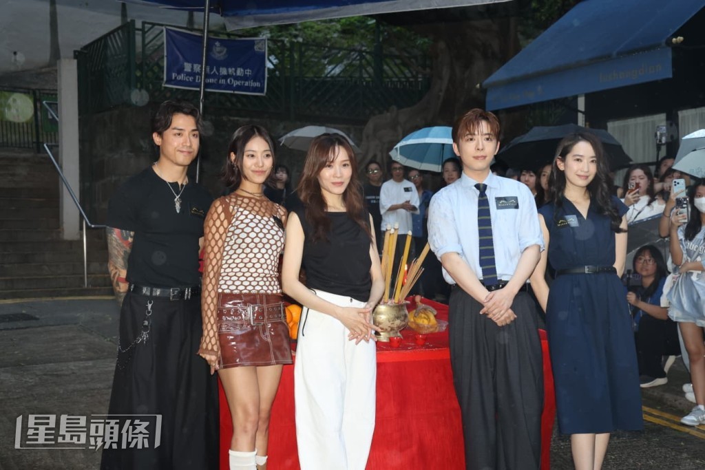 5位演員要冒雨影大合照。
