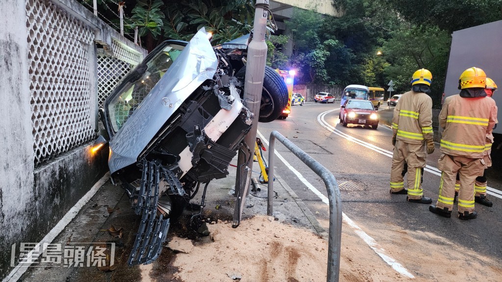 私家車失控越線並翻側，困在石牆與燈柱之間，司機一度被困車內。黎志偉攝