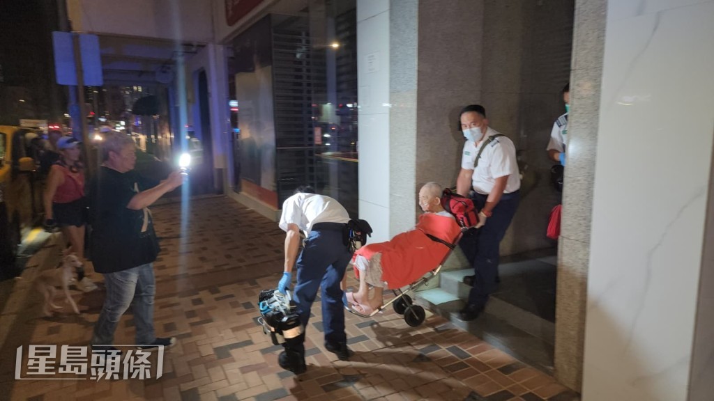 一名老翁因呼引困難不適,由救護員送往醫院治理。黎志偉攝 一名老翁因呼引困難不適,由救護員送往醫院治理。黎志偉攝