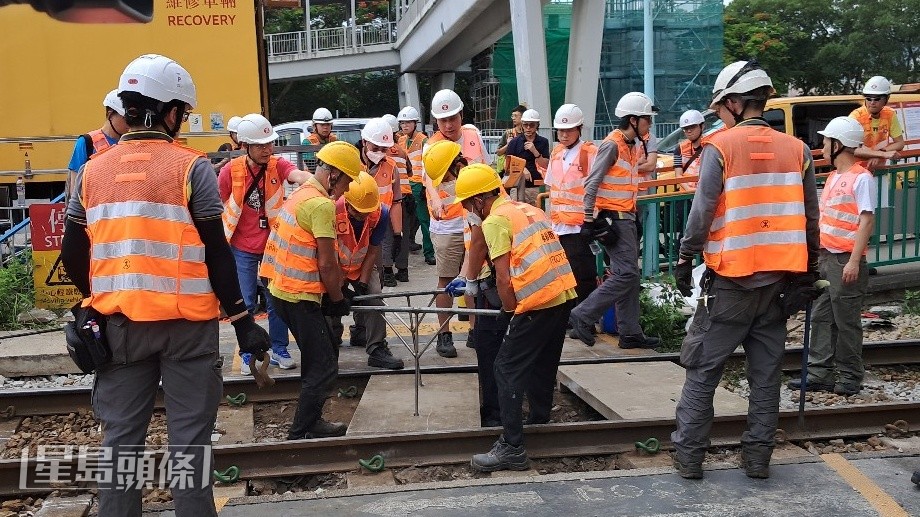 維修工人在鍾屋村站 行人過路線 重鋪石屎板。