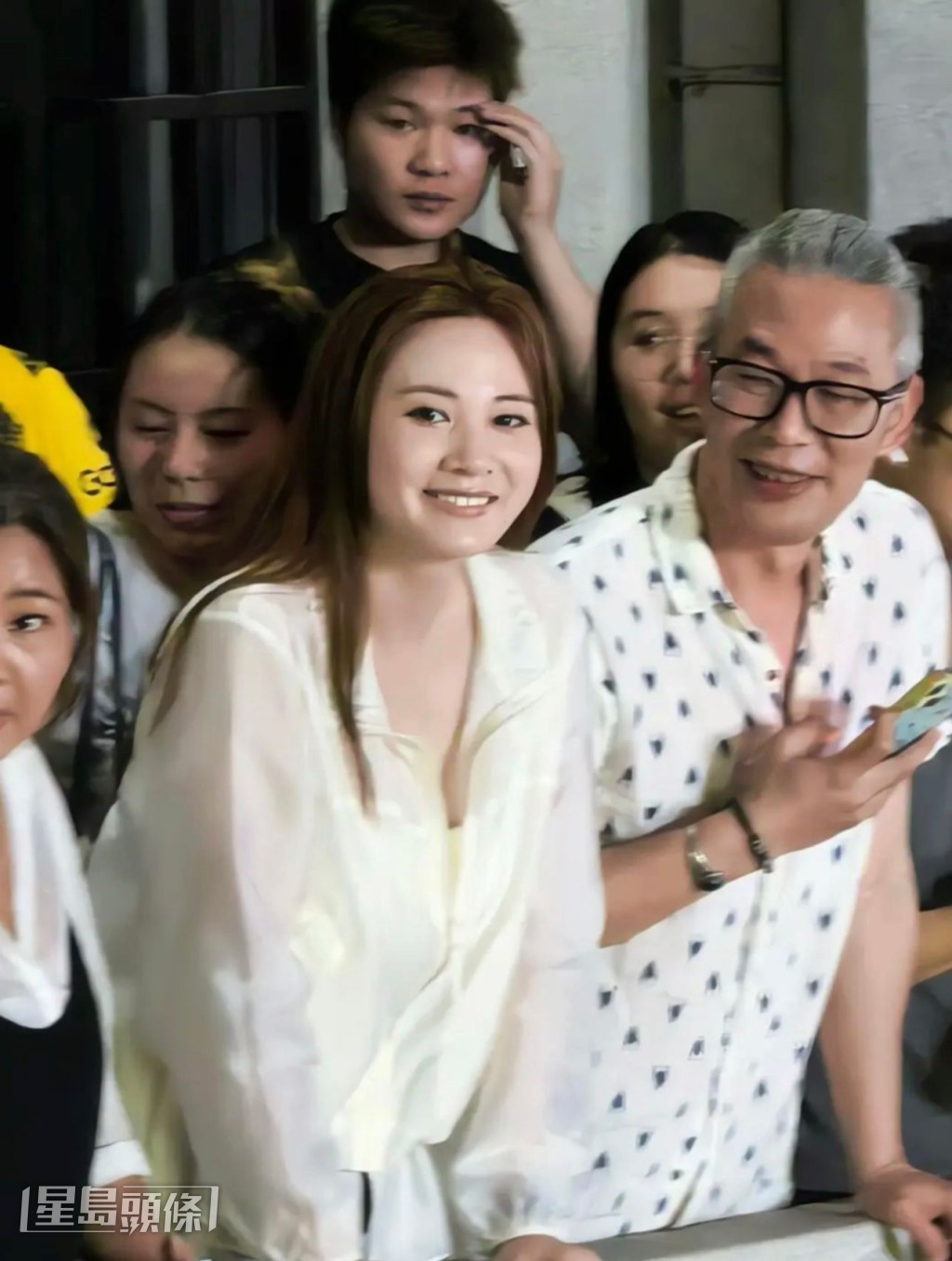她在工作人員護送下進場，心情大靚。