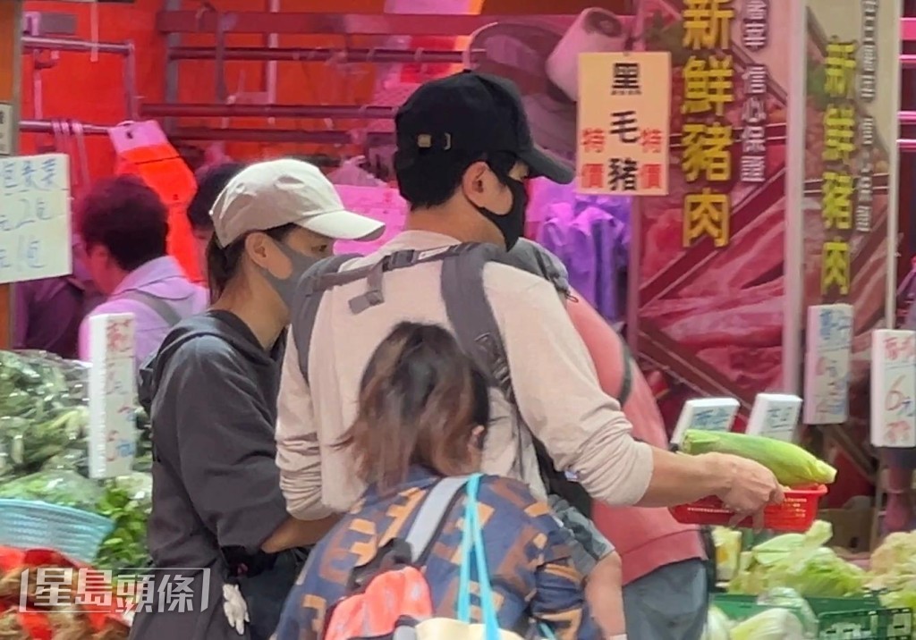 兩公婆在人群中穿梭，邊行邊商量。