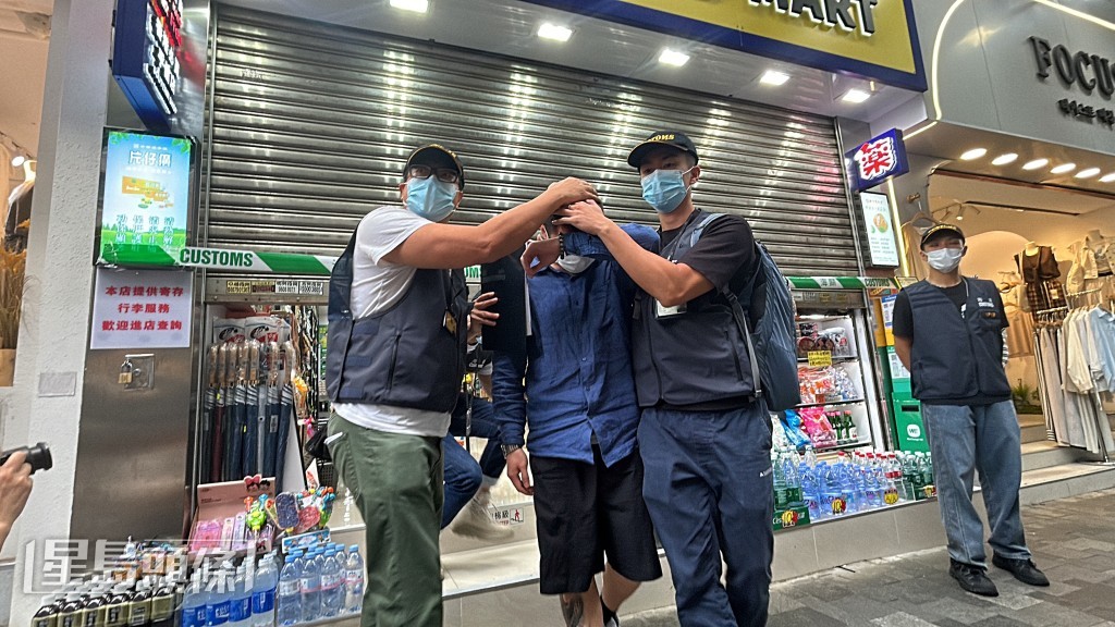 海關帶走涉案店員。林思明攝