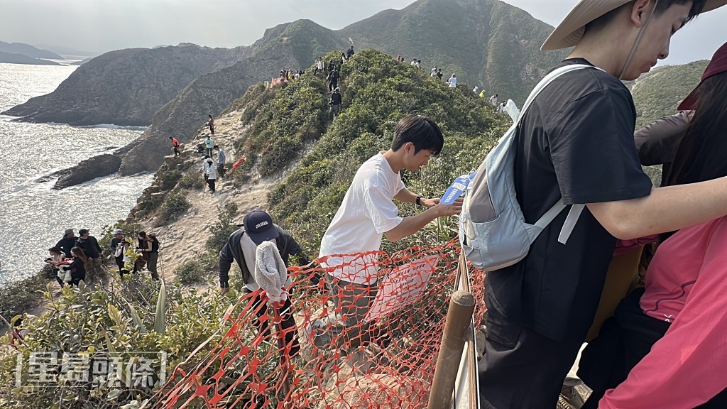 不少遊人無視警告,跨過圍障走近懸崖。劉漢權攝 不少遊人無視警告,跨過圍障走近懸崖。劉漢權攝