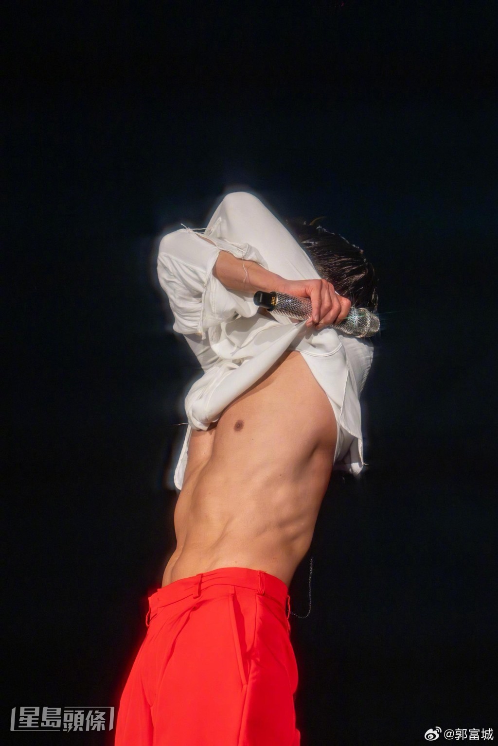 他刻意拉高恤衫展露胸腹肌，當然令台下觀眾驚喜狂呼。