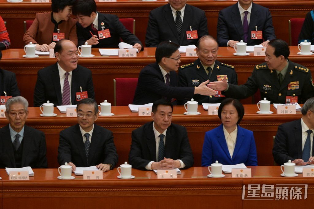 坐下之后分别与坐其左手旁的中央军委委员张升民及刘振立握手。苏正谦摄