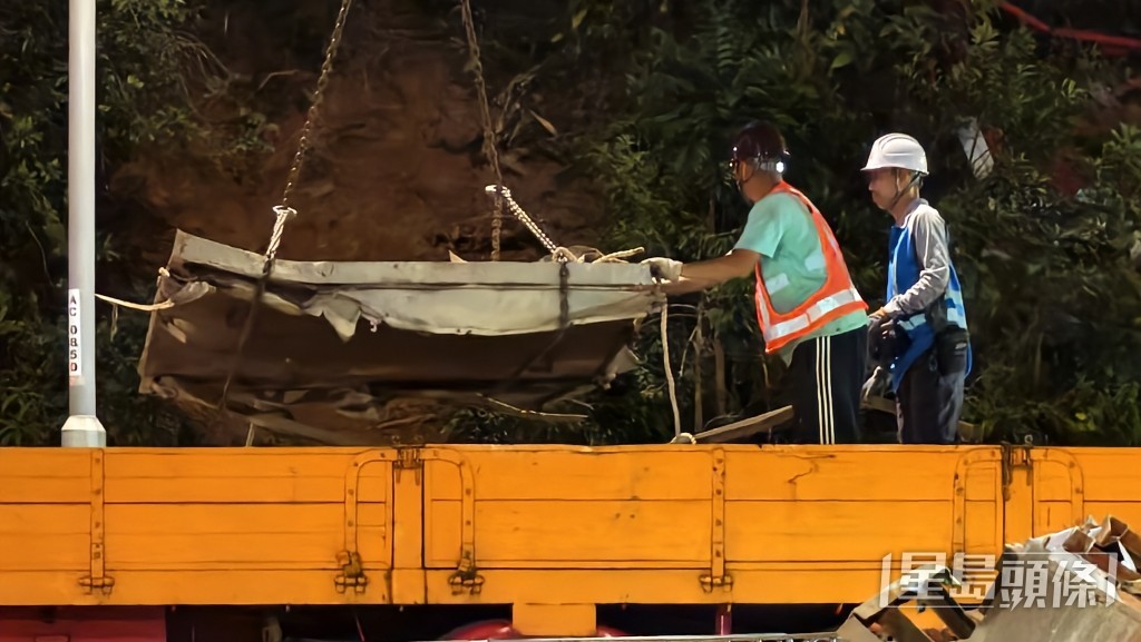 工人夜晚清理大窩口道散落的金屬殘骸。