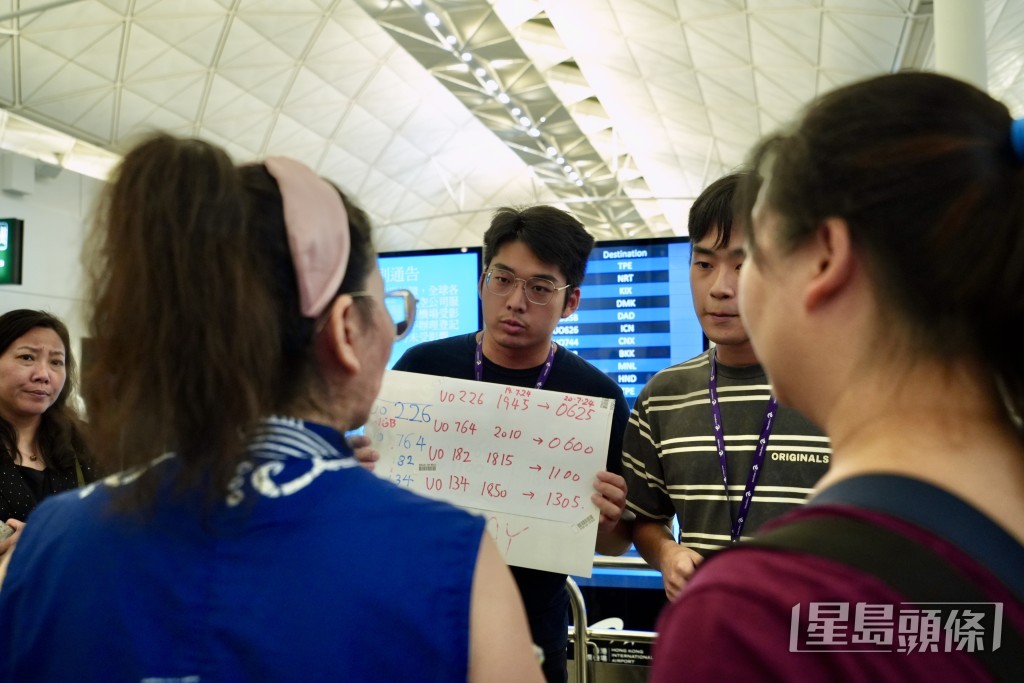 今日有航空公司职员用手写牌安排乘客登机。刘骏轩摄