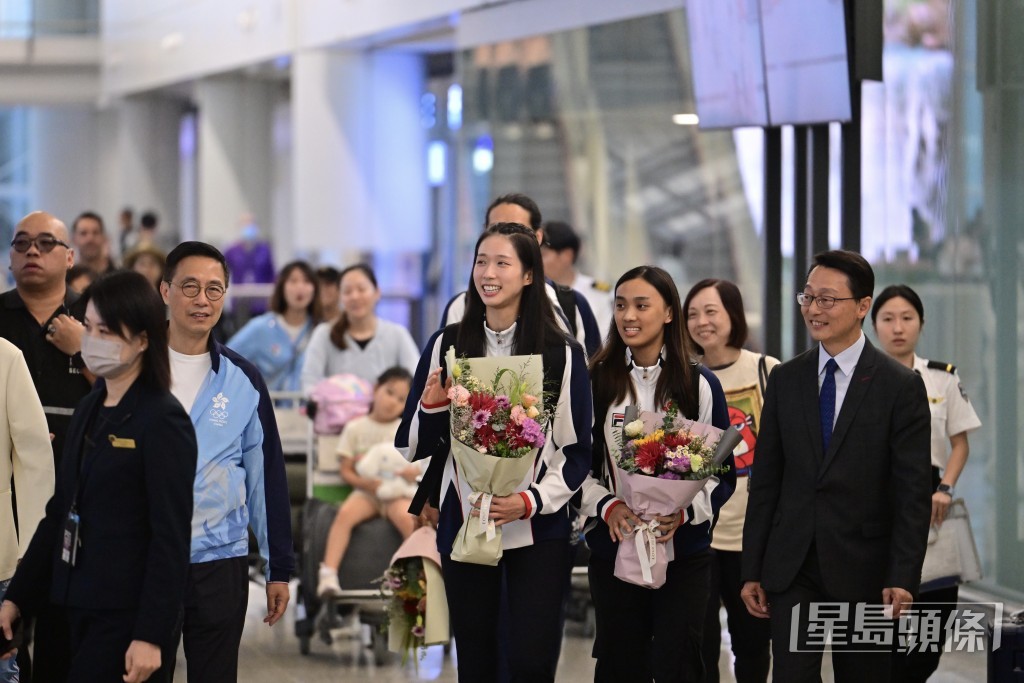 江旻憓与队友陈诺思，在文化体育及旅游局局长杨润雄陪同下步出机场禁区。陈极彰摄