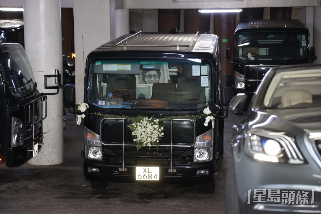 樂易玲的大仔捧著爸爸遺照登上靈車。 樂易玲的大仔捧著爸爸遺照登上靈車。