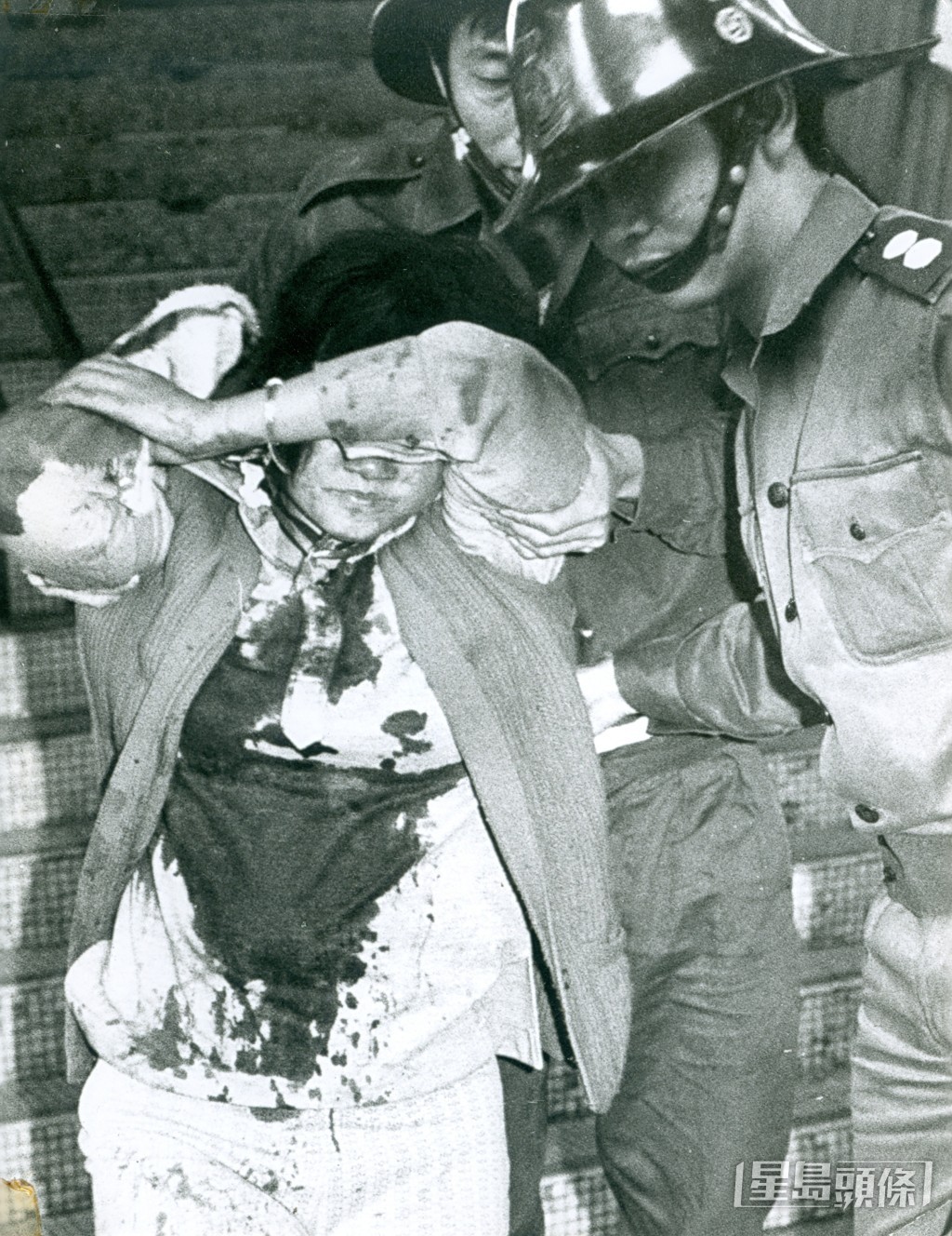 1973年,鰂魚涌英皇道福昌大樓,一名男子因借錢不遂,殺害一名朋友及在該單位放火,疑兇陳梓樑(又名陳仲文及黃志恒,亦疑為澳門八仙飯店十人命案疑兇)。圖為福昌樓劫殺案,其中一名女傷者被救出。 1973年,鰂魚涌英皇道福昌大樓,一名男子因借錢不遂,殺害一名朋友及在該單位放火,疑兇陳梓樑(又名陳仲文及黃志恒,亦疑為澳門八仙飯店十人命案疑兇)。圖為福昌樓劫殺案,其中一名女傷者被救出。