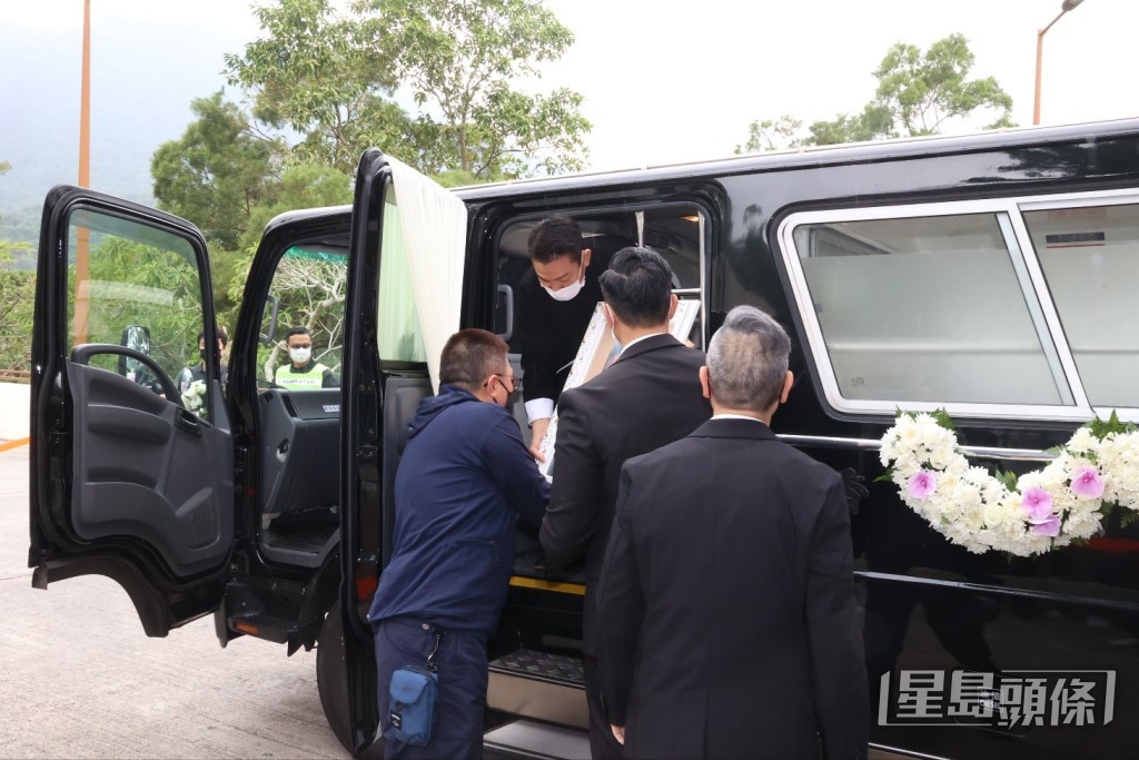 當靈車抵達火葬場後，劉德華捧着亡父遺照。