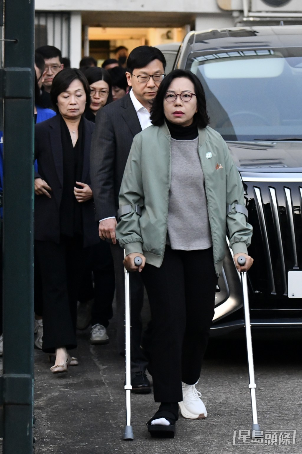 麥美娟撐著拐杖探望災民。