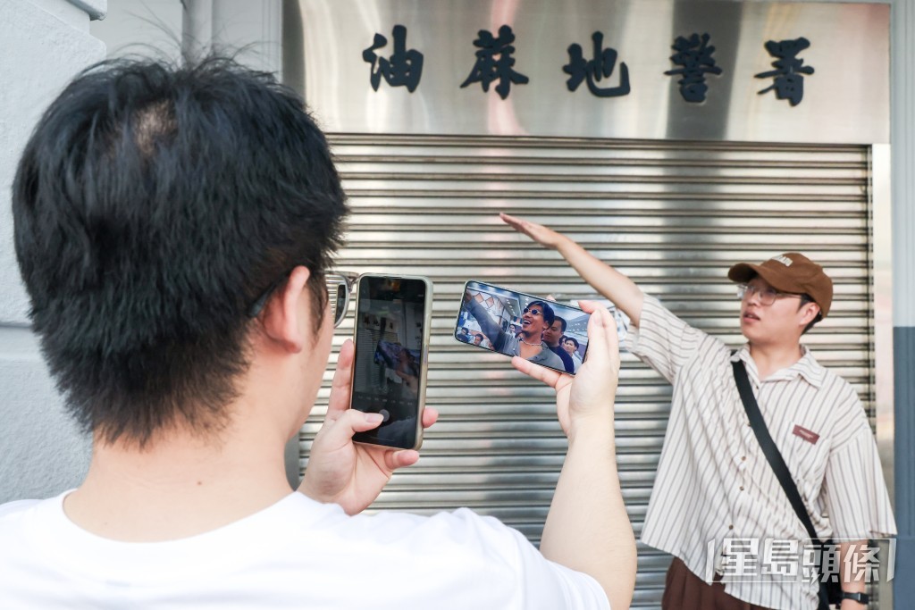 有遊客在舊油麻地警署外，扮演「烏鴉」張耀揚。