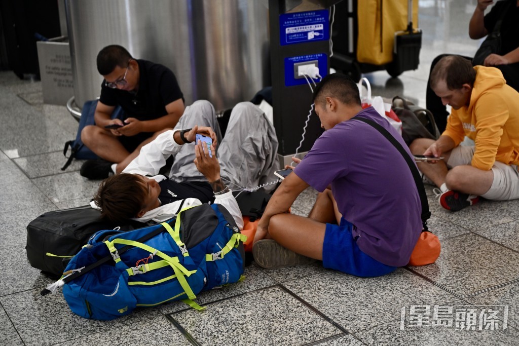 受航班取消或延誤影響,部分旅客滯留機場,席地而睡或為行動裝置充電。 受航班取消或延誤影響,部分旅客滯留機場,席地而睡或為行動裝置充電。