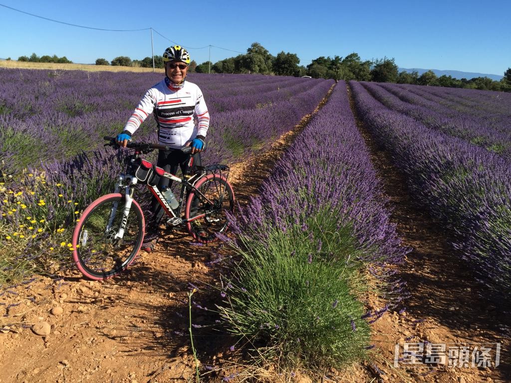 早年單車歐洲遊行程中，梁榮武於法國的花田留影。 受訪者提供