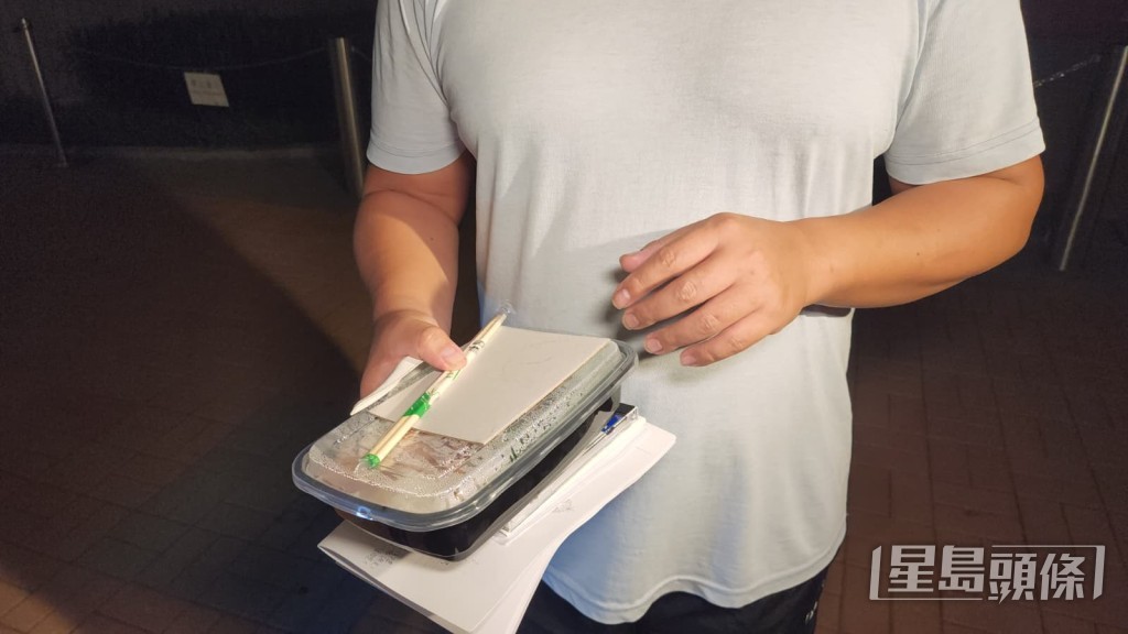 曾男手持入境處提供的飯盒,離開總部後即場開餐。黎志偉攝 曾男手持入境處提供的飯盒,離開總部後即場開餐。黎志偉攝