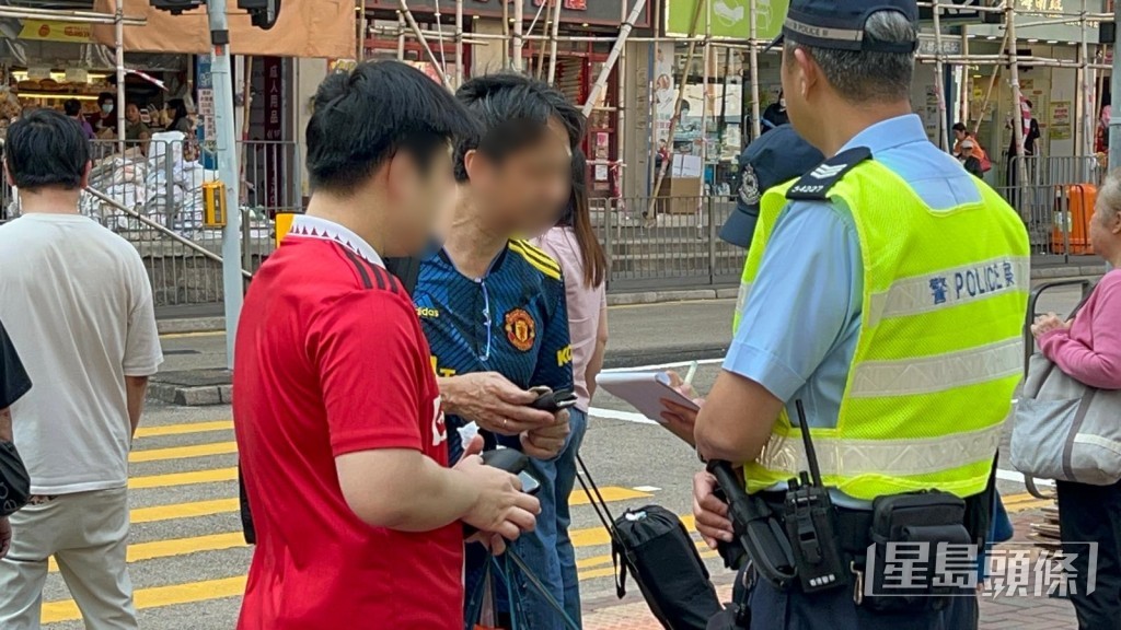 林先生见车流停止,遂偷步过路,被警员截停警告。 林先生见车流停止,遂偷步过路,被警员截停警告。