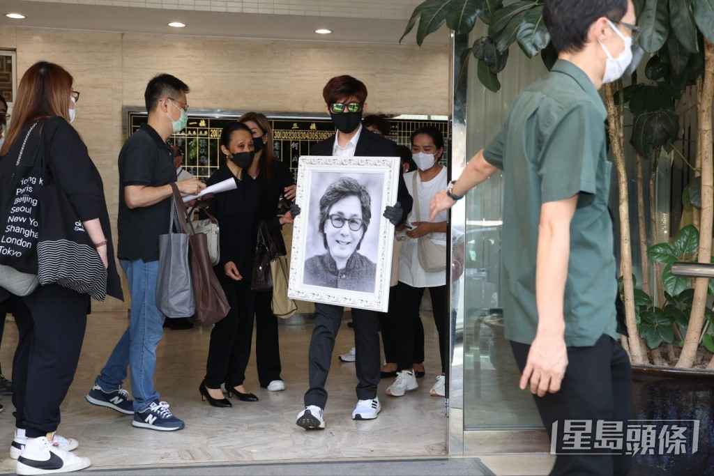 樂易玲的大仔捧著爸爸遺照登上靈車。 樂易玲的大仔捧著爸爸遺照登上靈車。