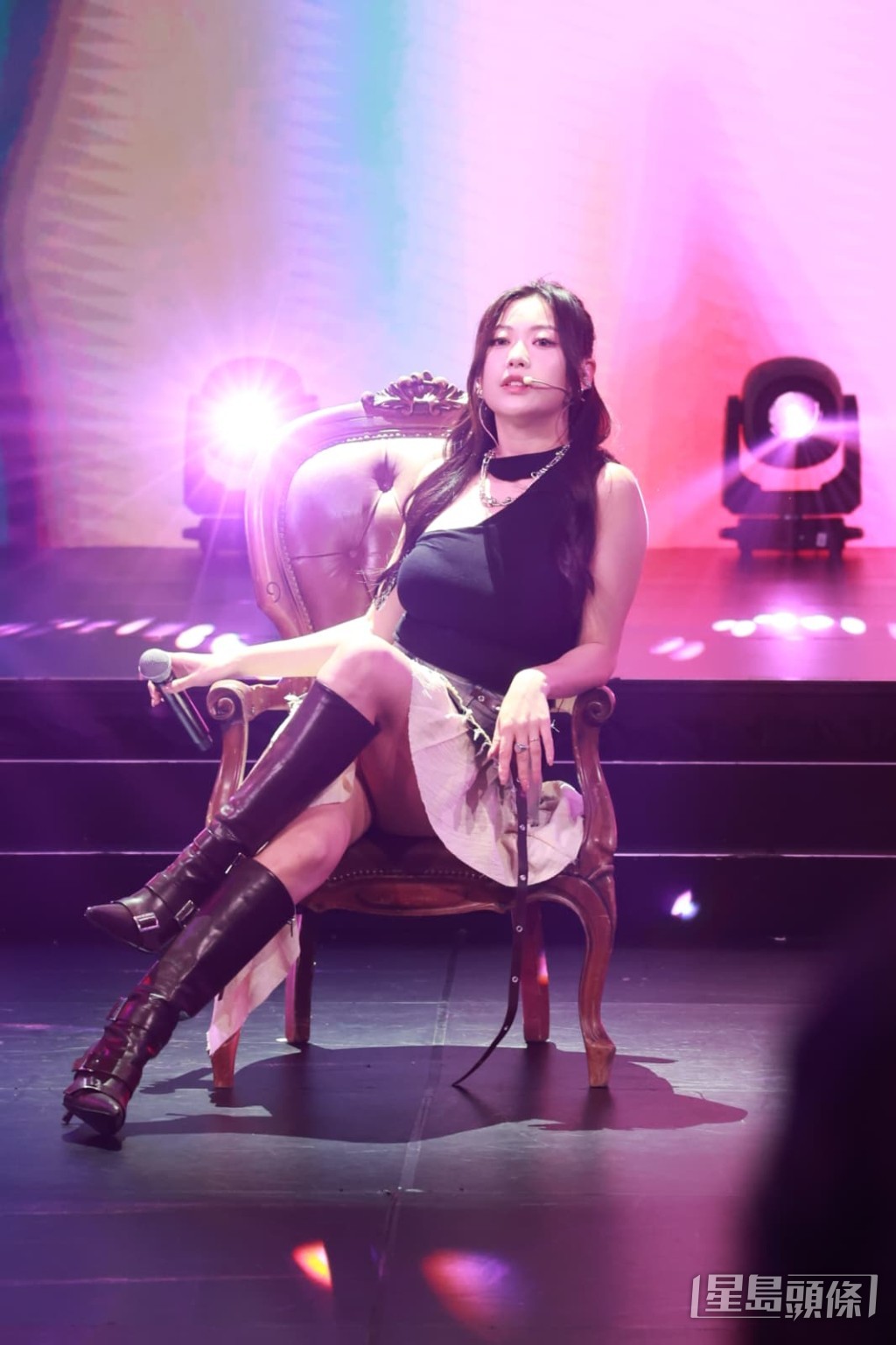 性感女神Kylie C.，身穿緊身黑色背心及短裙在王座上大跳辣身舞。